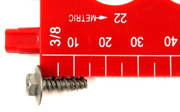 A red ruler with a metal screw and a measuring tape.