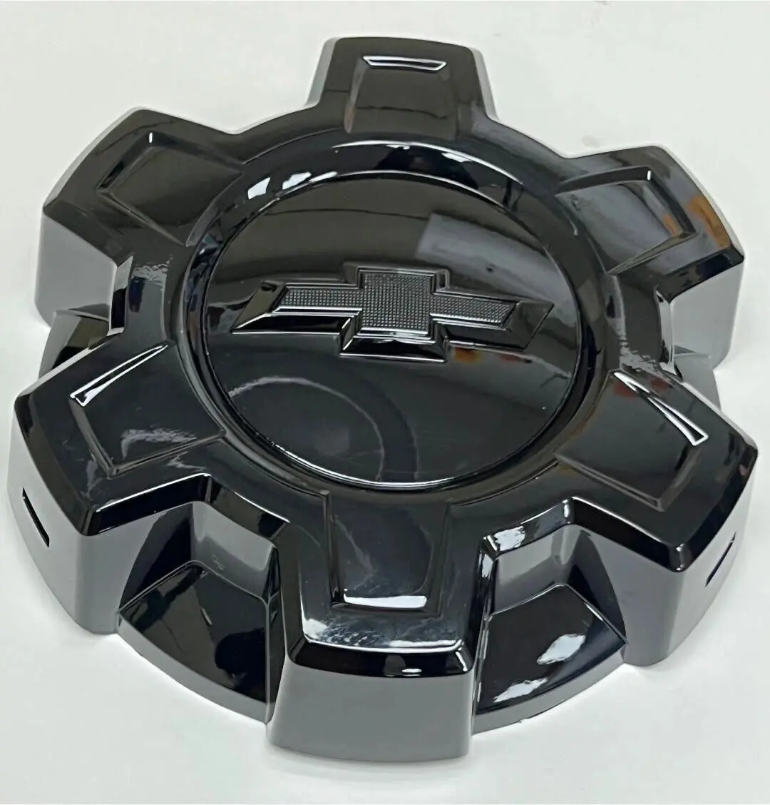 A black chrome wheel cap with the chevrolet logo on it.