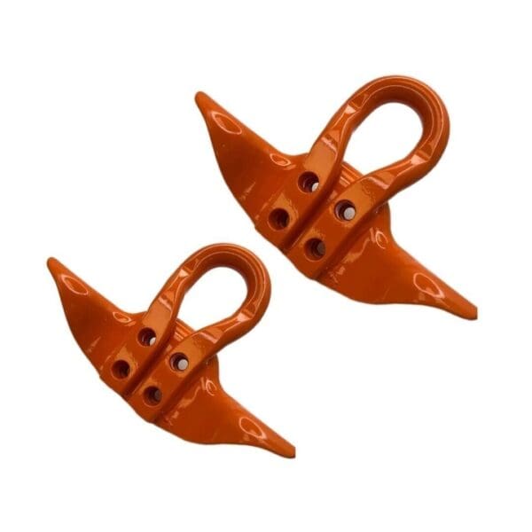 A pair of orange hooks are hanging on the side of a wall.